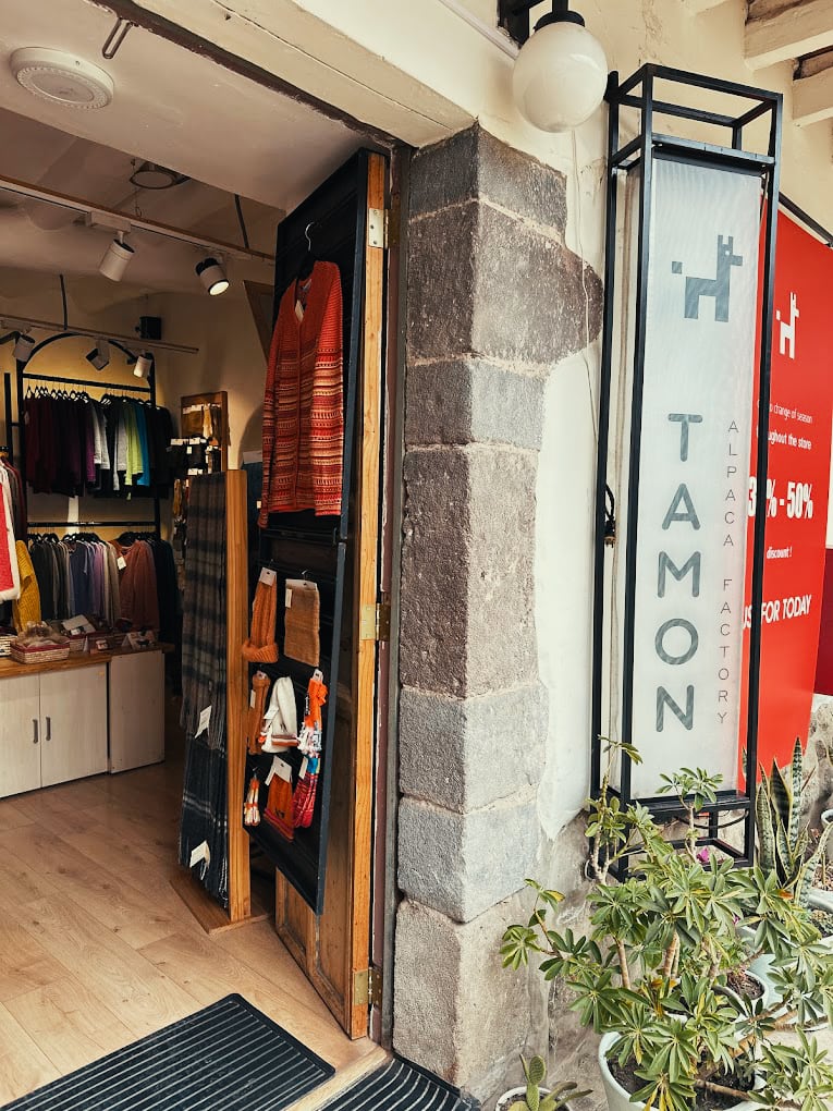 flagship_storefront_picture a front picture of the main entrance for the alpaca clothing store based in cusco, peru. the store name alpaca tamon studio